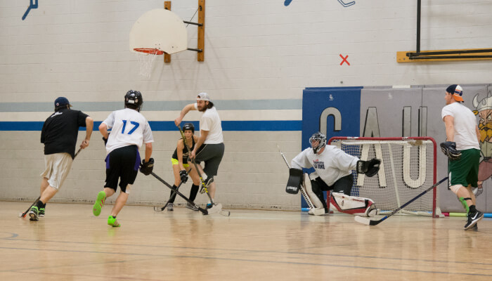 a group of people playing hockey near the net